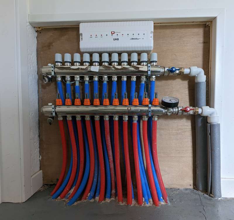 A number of red and blue pipes that got from taps into the ground